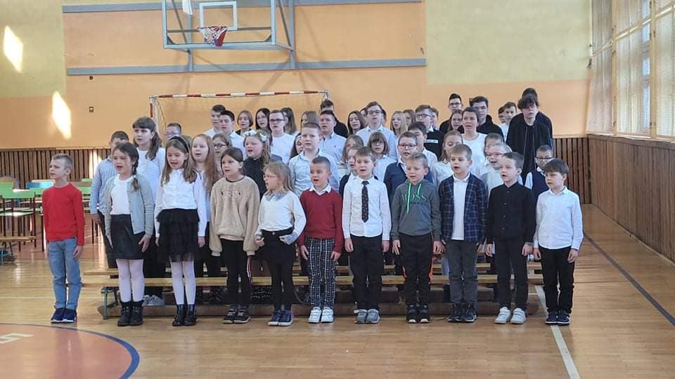 Grupa uczniów śpiewająca hymn POlski