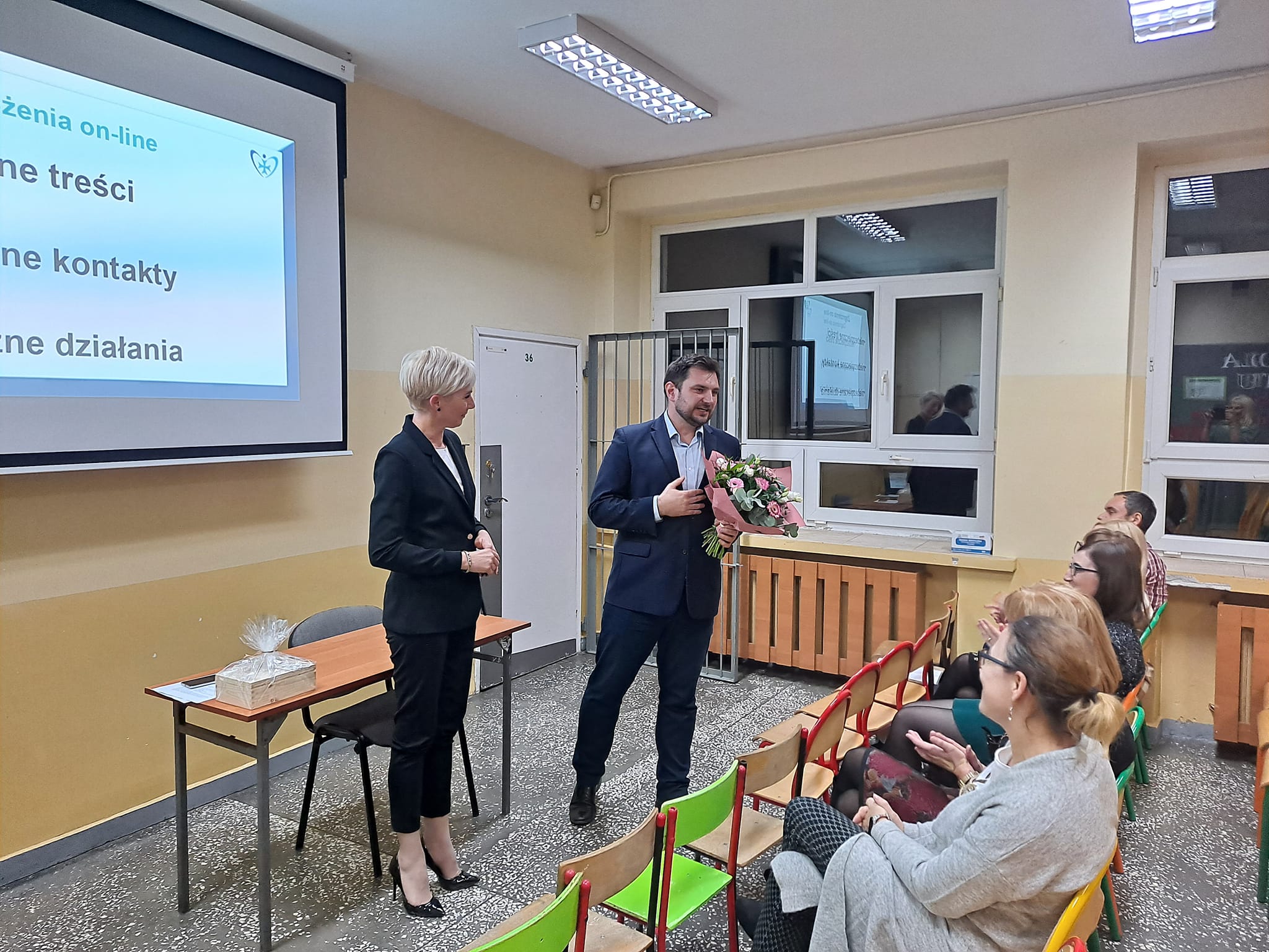 Pani Dyrektor wręcza kwiaty panu prowadzącemu zajęcia