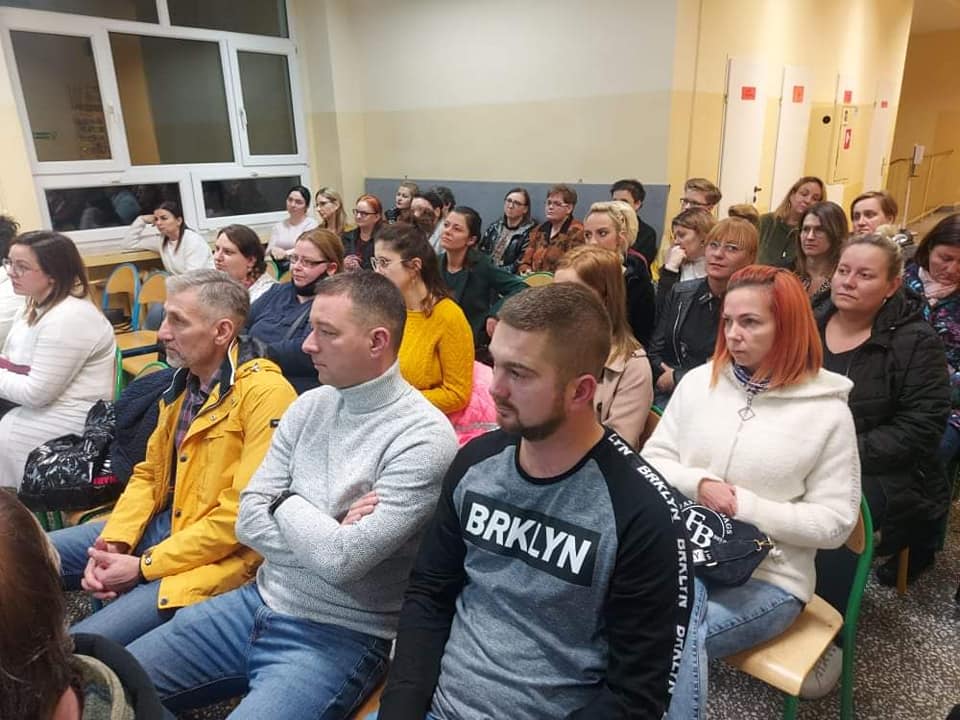 Rodzice siedzący na korytarzu szkolnym