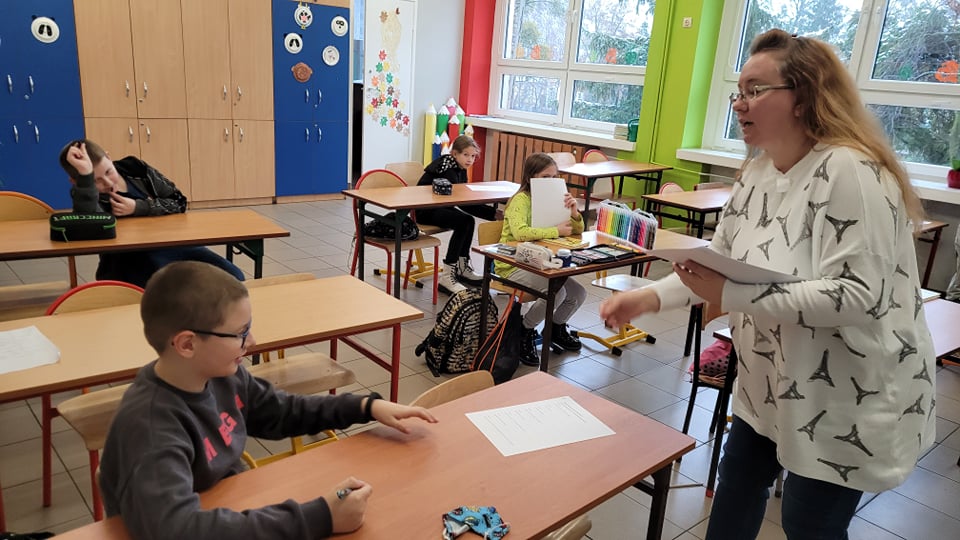 Nauczyciel rozdaje karty pracy
