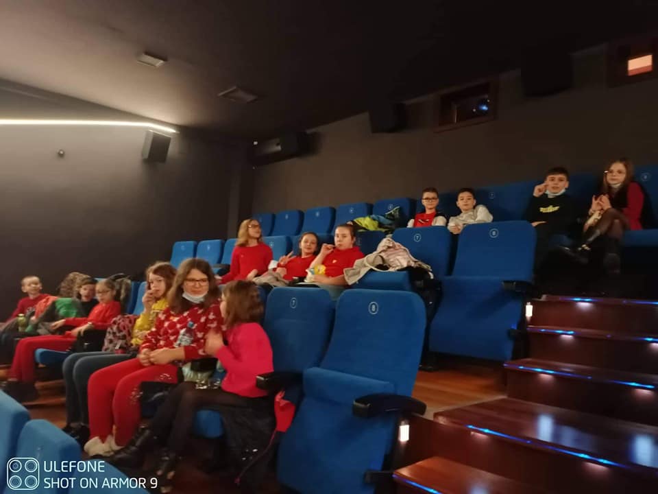 Uczniowie siedzą w fotelach w sali kinowej
