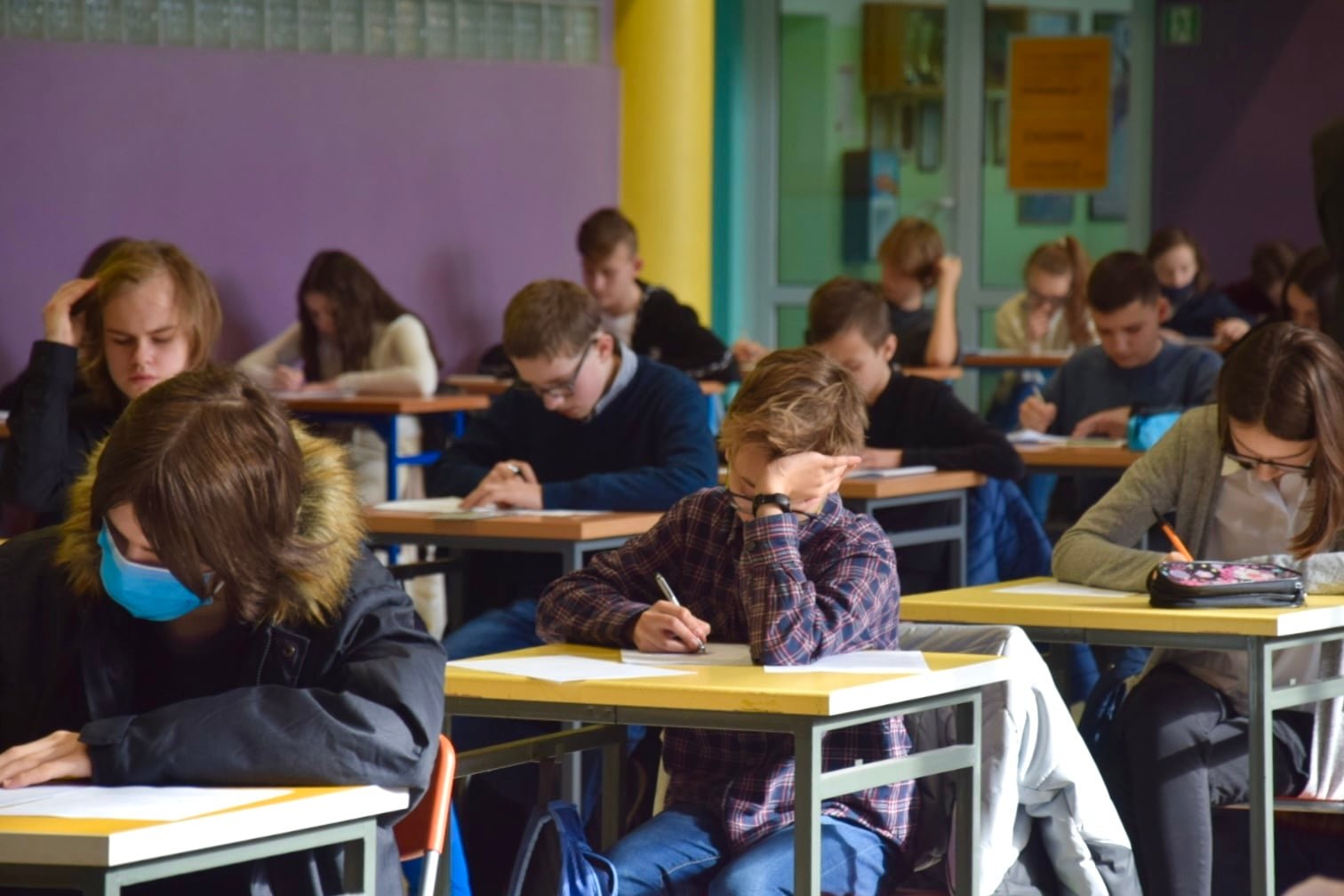 grupa uczniów siedząca przy ławkach