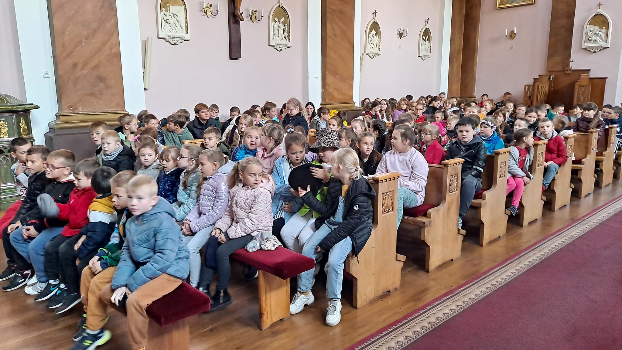 Uczniowie siedzą w kościele