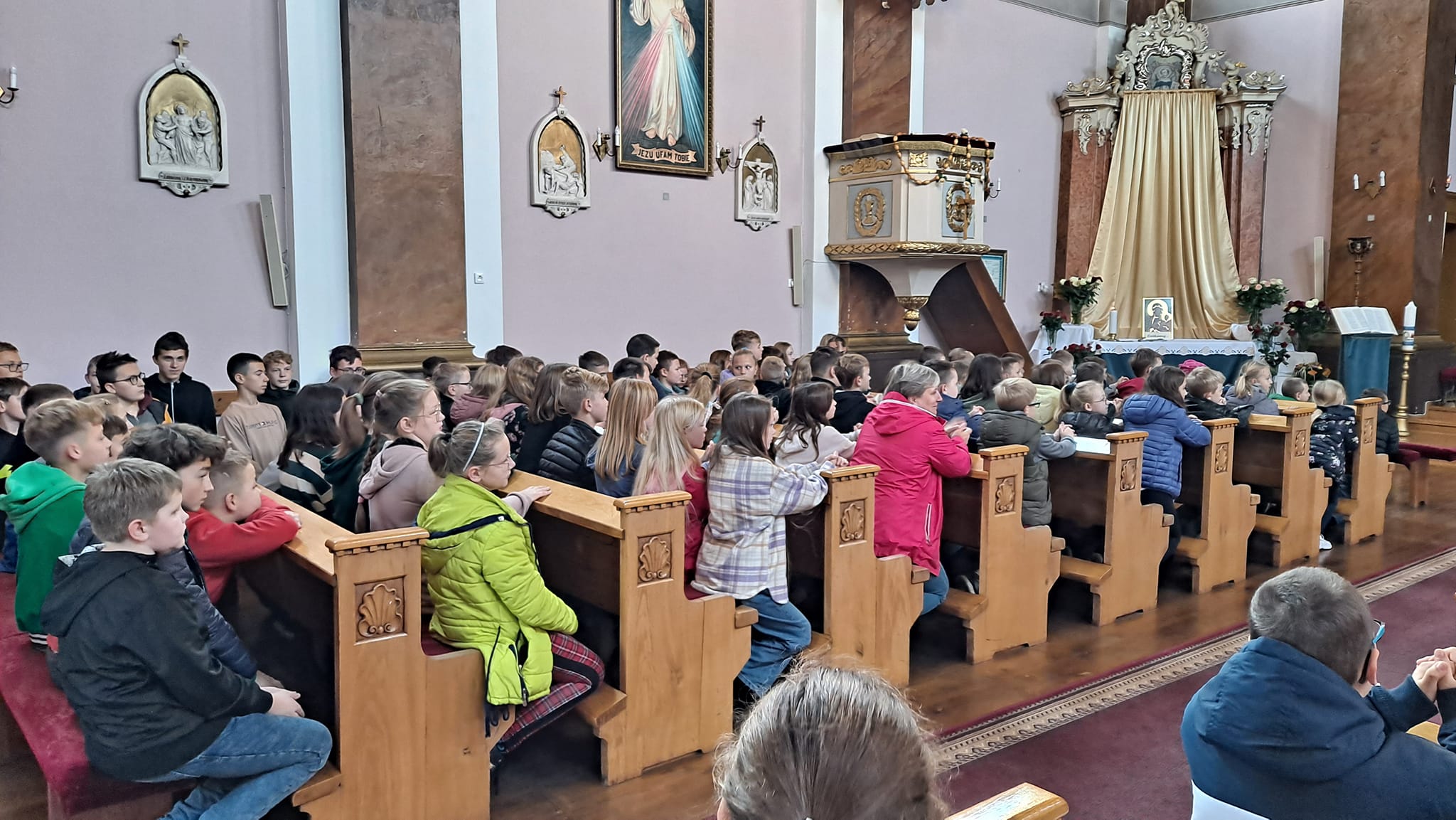 Uczniowie siedzą w kościele