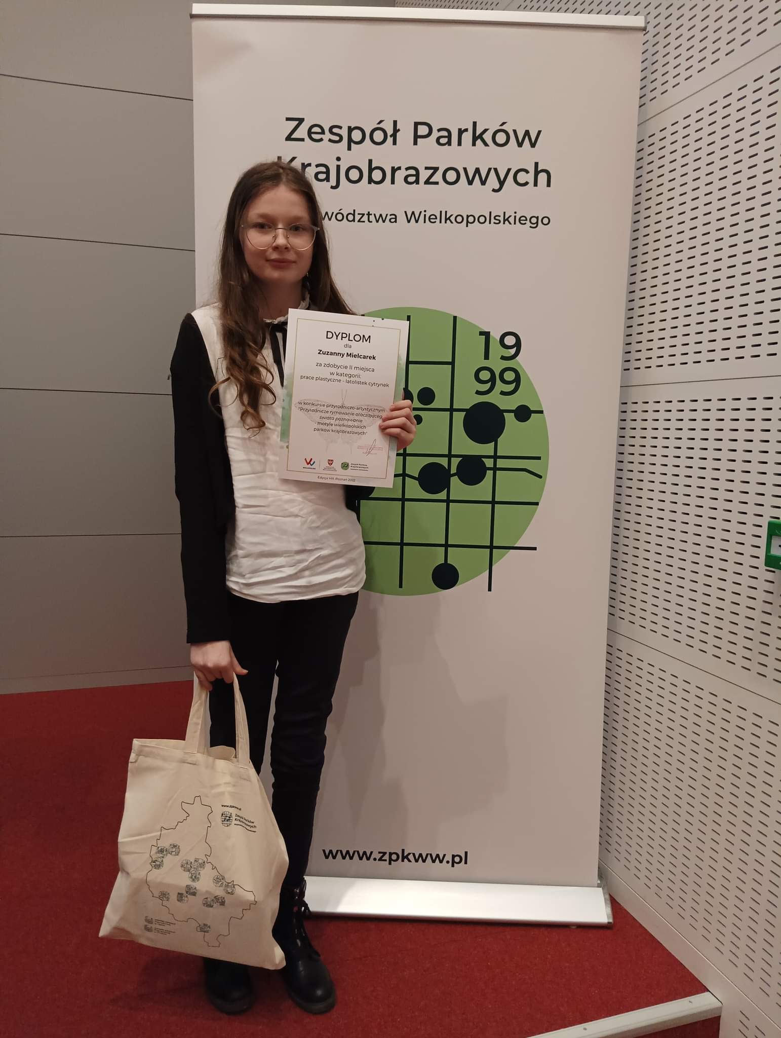 dziewczynka na tle baneru konkursu