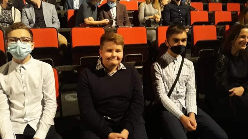 uczniowie siedzący w teatrze